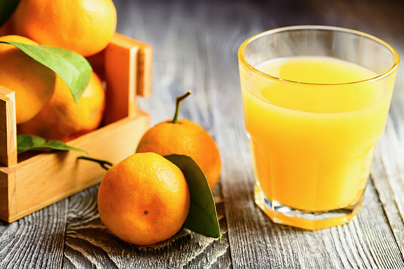 Fresh oranges and a glass of juice showing orange juice hydration
